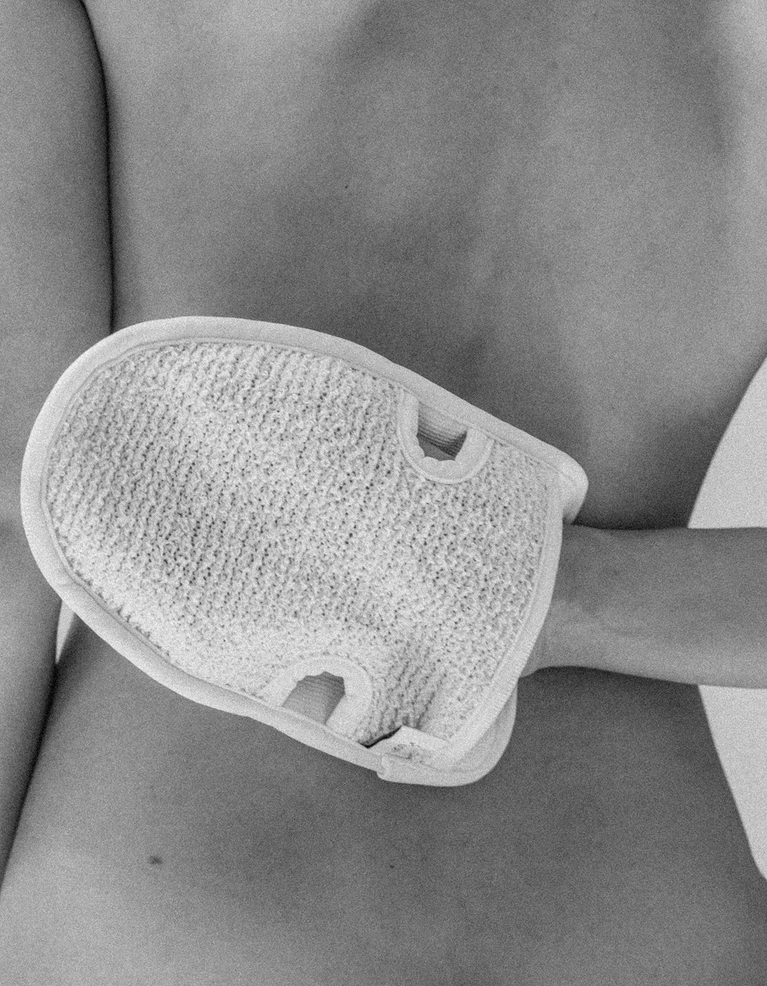 Frau mit Peelinghandschuh am Rücken